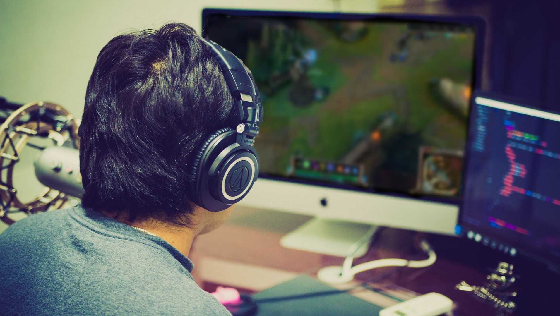 A gamer sitting at his rig, seen from behind